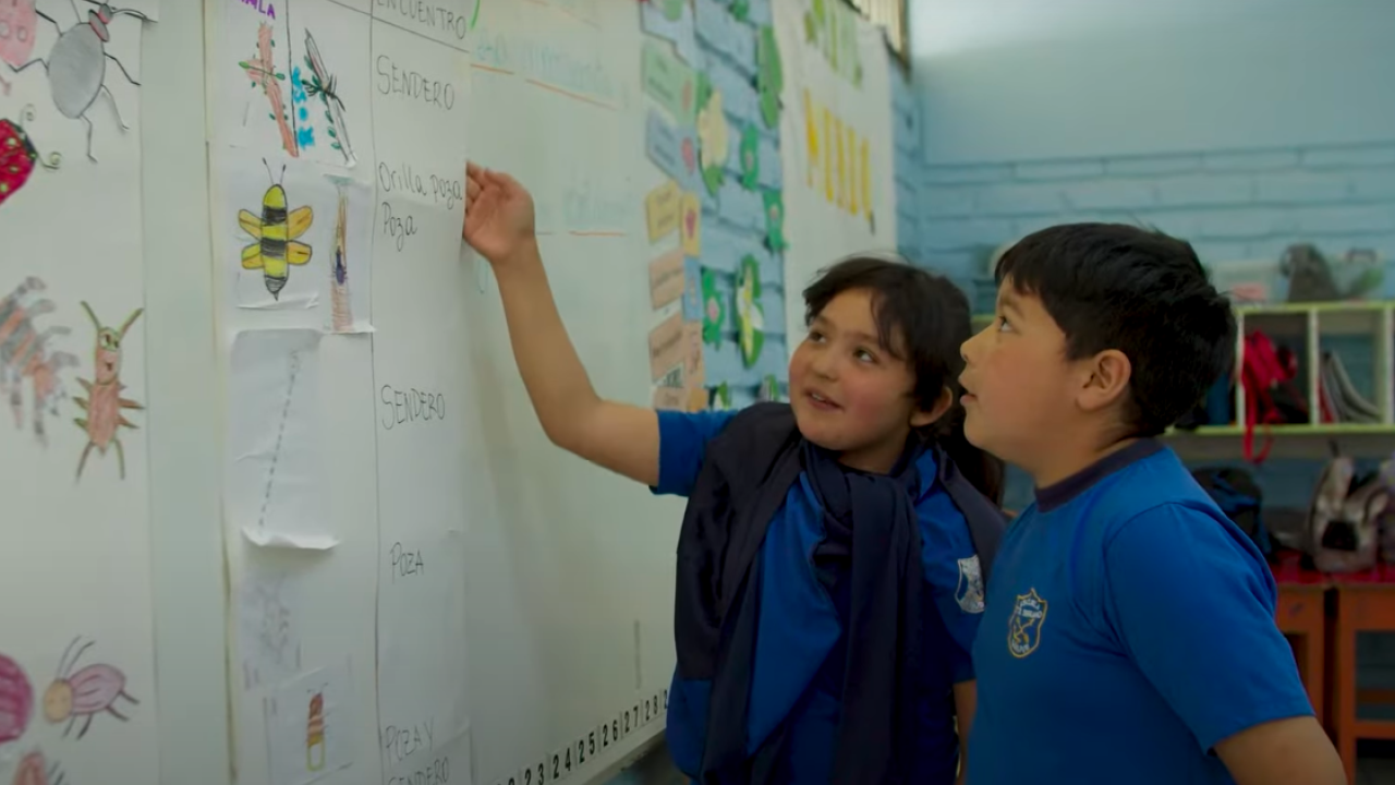 Imagen de 2 niños apuntando a una pizarra