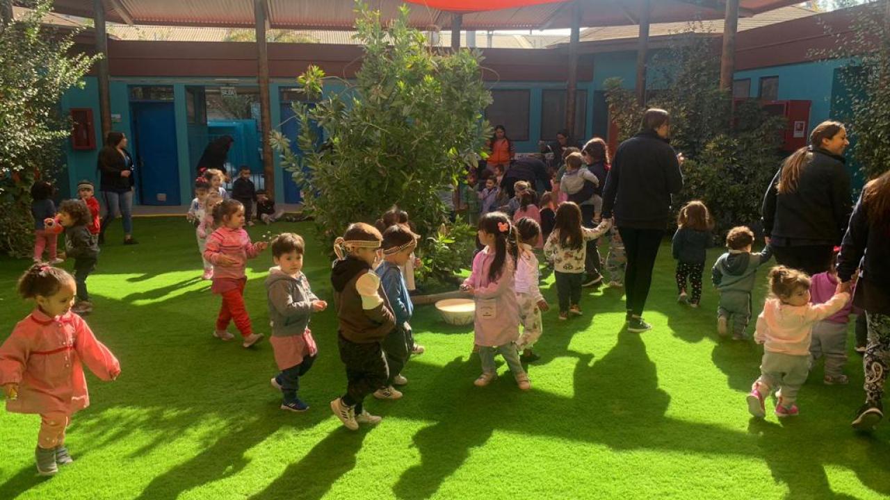 Parvulos participando de actividad al aire libre dentro de un jardín infantil
